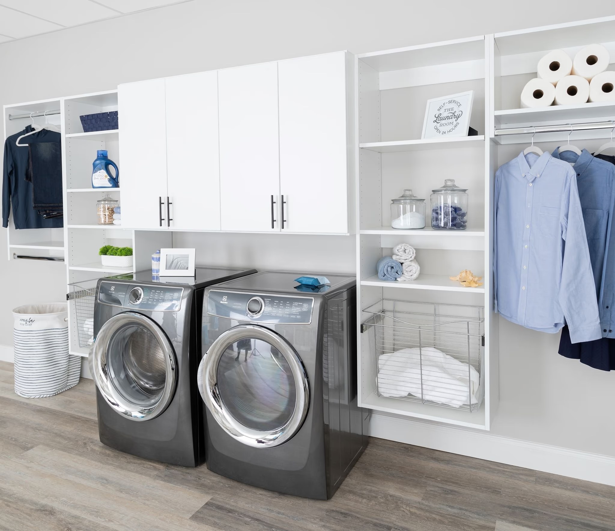 Laundry room storage with white cabinets, shelves, and washer and dryer