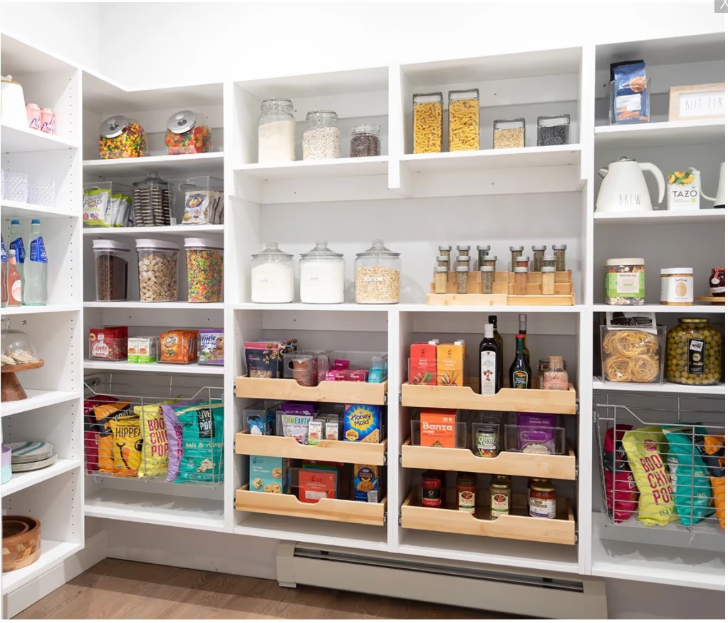 Organized white pantry with shelves, jars, baskets, and pull-out storage